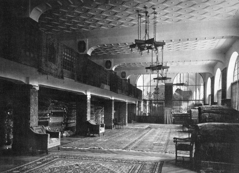 Teppichsaal, 1910/11 "Der Geschäftsbetrieb gab die Veranlassung zur Beschaffung weiter, lichter, hallenartiger Räume, so entstanden der große Raum für orientalische Teppiche, und darüber der Raum für deutsche Teppiche [...] Die Ausstattung wurde wiederum durch den Zweck, dem die Räume dienen, bedingt. In den Verkaufsräumen für Teppiche ist sie ganz einfach, da ja die von der Galerie herabhängenden Teppiche, die Stoffe an den Wänden selbst eine ausgesucht feine Dekoration des Raumes bilden". (Kunst- und Handwerk 61 [1910], Heft 1, S. 4). Quelle: Kunst und Handwerk 61 (1910/11), Heft 1, S. 2.